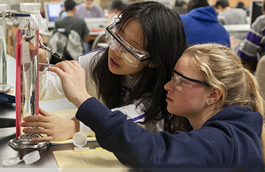 Two students in PPE working in lab